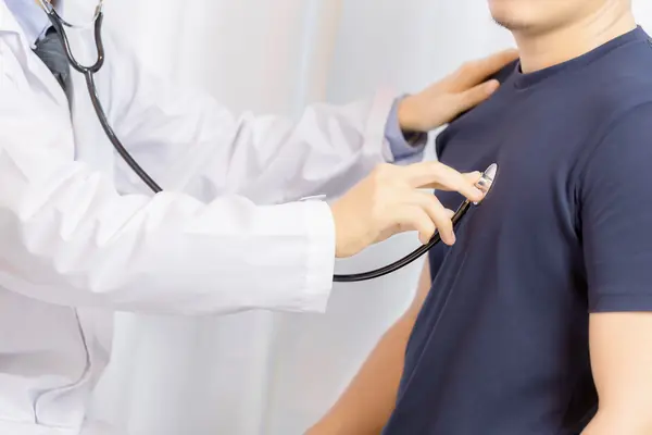 hombre-joven-del-examen-del-doctor-con-el-estetoscopio-en-hospital_result